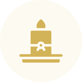 A simple golden candle with a flame on a plate.