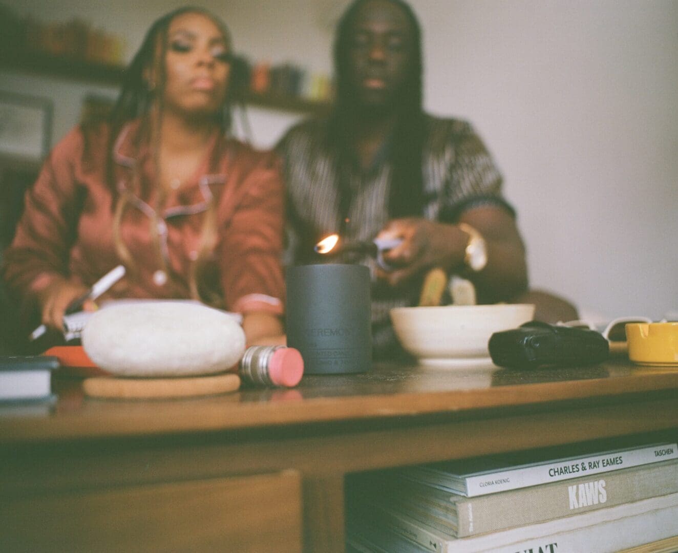 Two people sitting at a table with bowls and food items.