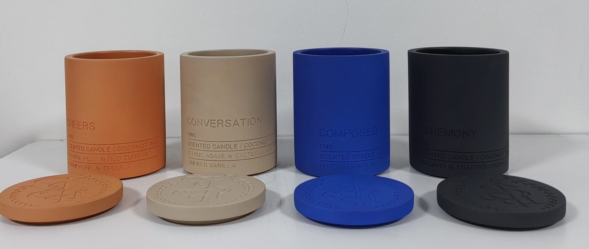 Three cylindrical containers with matching lids in beige, blue, and black.