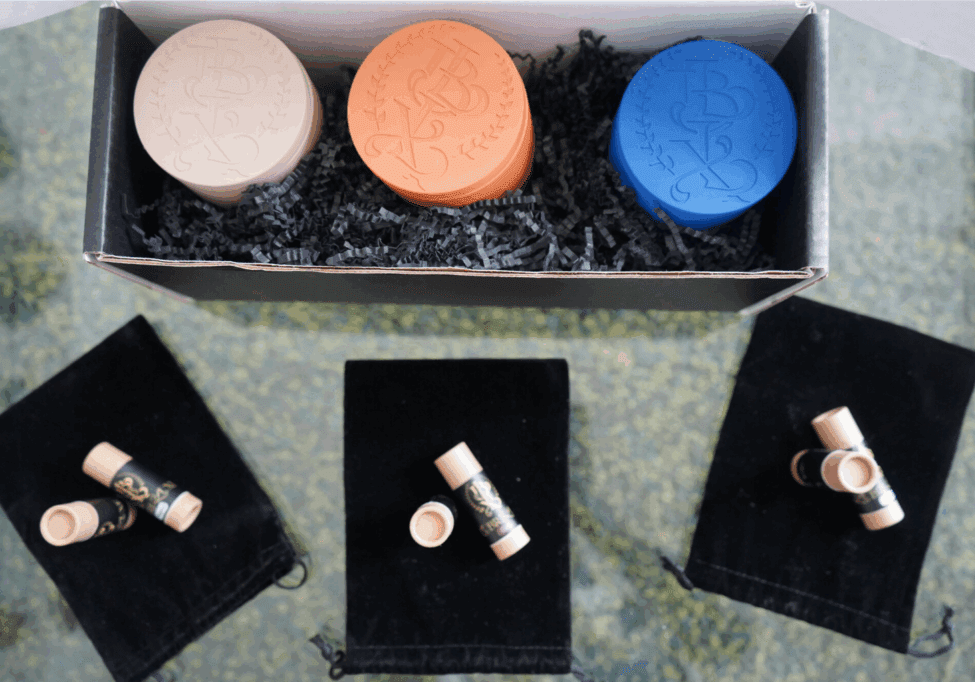 A set of colorful round soaps and small skincare bottles displayed in a box.